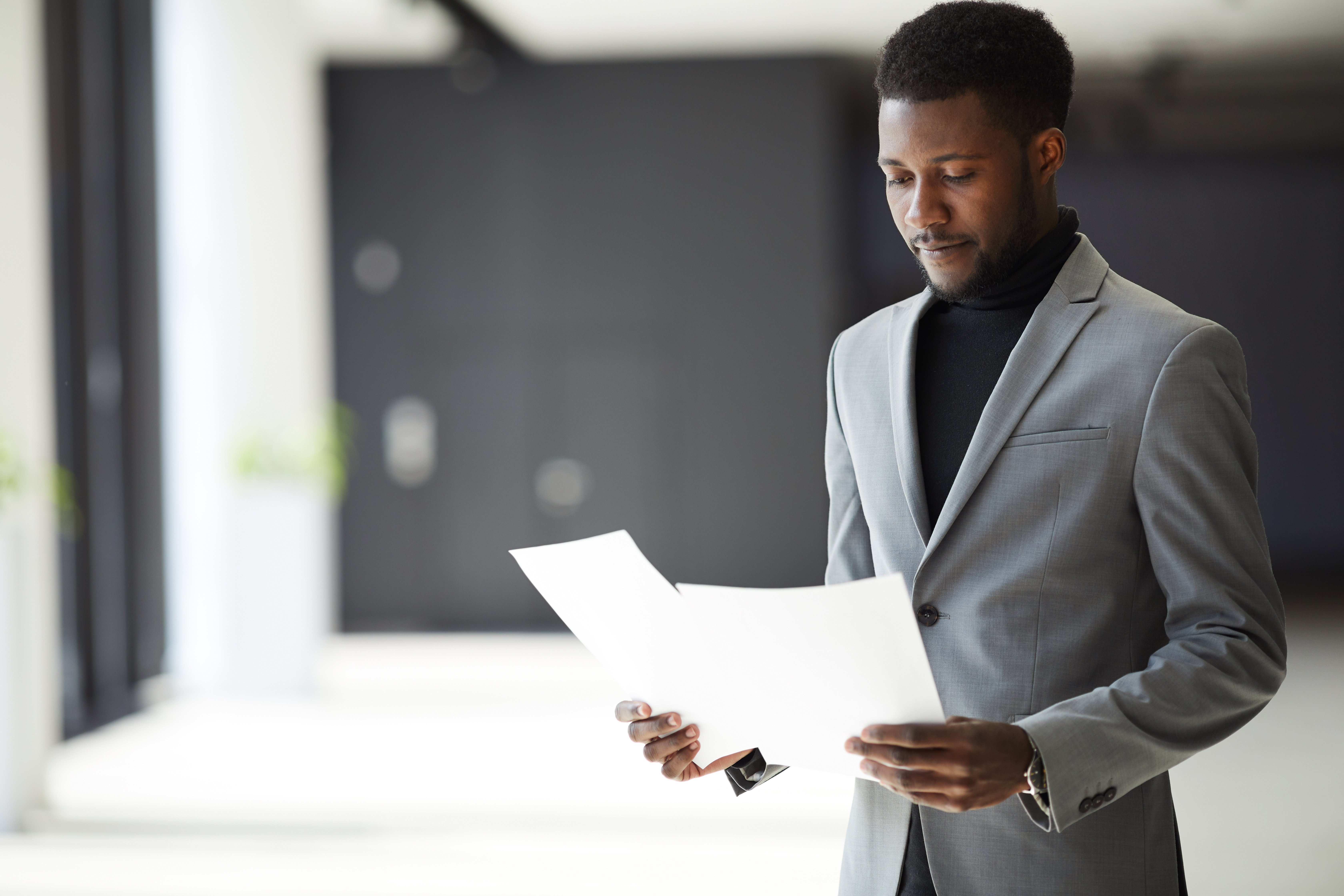 african-american-manager-examining-documents-M248NER african-american-manager-examining-documents-M248NER